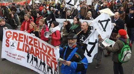 Solidarity For All in actie: hopen mensen met 'Grenzeloze Solidariteit' banner en Solidarity For All vlaggen
